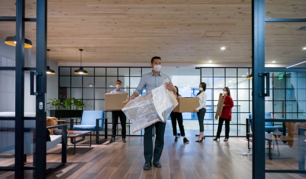 business-people-moving-into-a-new-office-wearing-facemasks-picture-id1280055643