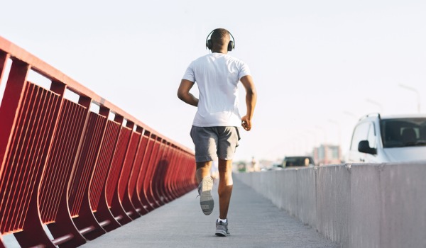 sporty-african-american-guy-running-along-the-bridge-picture-id1169134296
